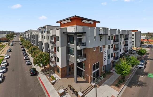 a row of apartment buildings with a parking lot in the foreground