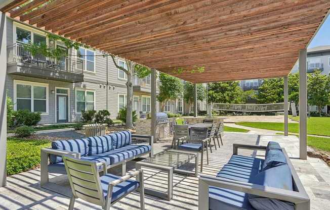A wooden patio with blue cushions and chairs.