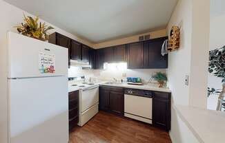 a kitchen with white appliances and dark wood cabinets