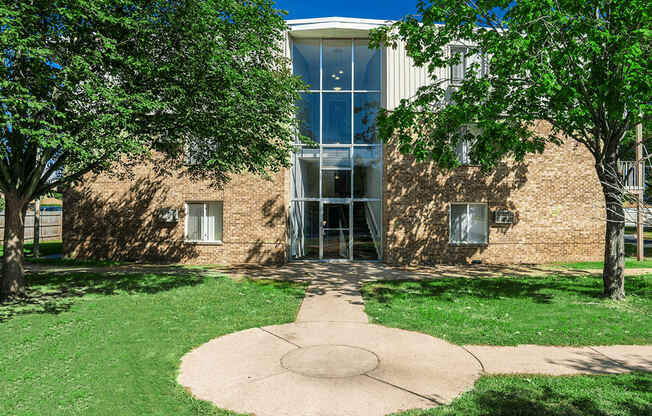 A building with a glass entrance is surrounded by trees.