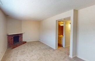 an empty living room with a brick fireplace