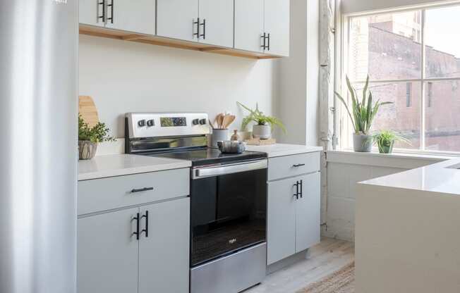 a kitchen with white cabinets and a wood floor at The 22 Apartments, St. Louis, 63103