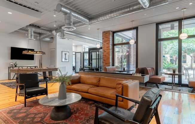 a living room with a couch and chairs and a large window