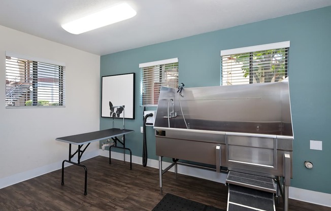 A room with a table and chairs and a stainless steel sink.