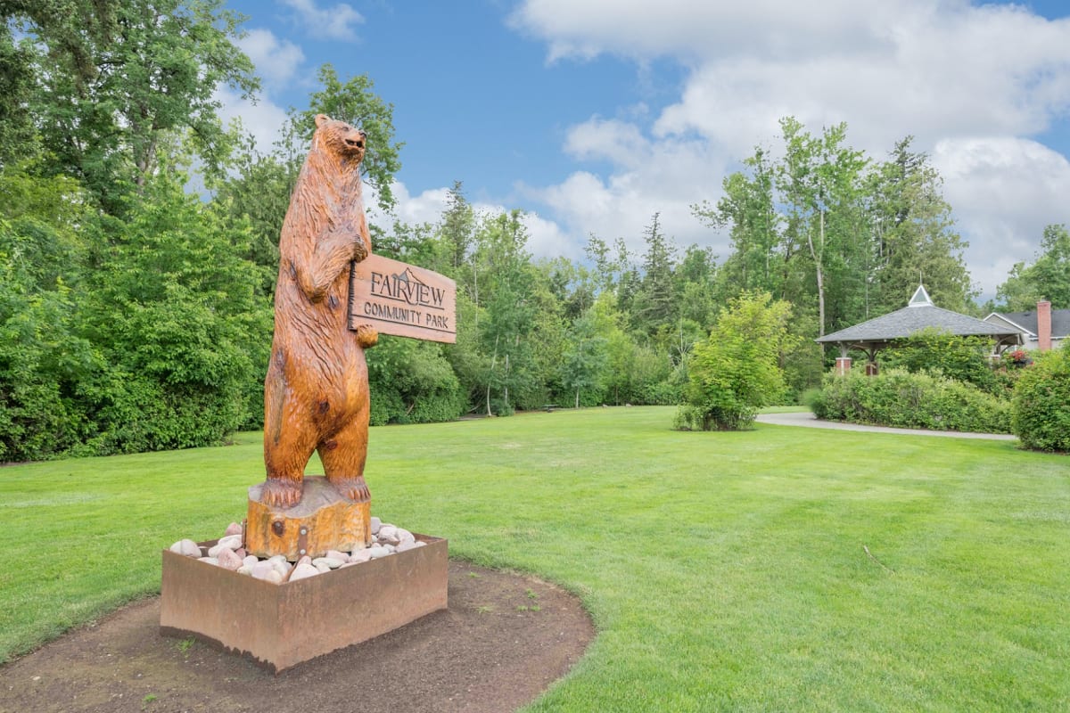 photo of a bear statue holding a sign that says 'fairview community park'