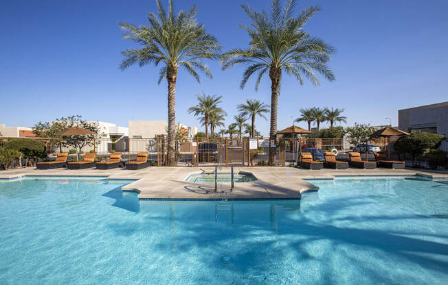 a resort style pool with lounge chairs and palm trees