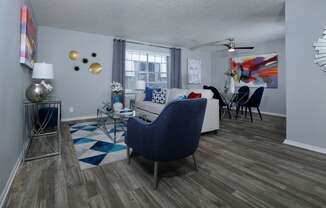 Living room and dining area in Stadium 700 apartments in Arlington  tx with modern furniture, luxury plank flooring, and large window.