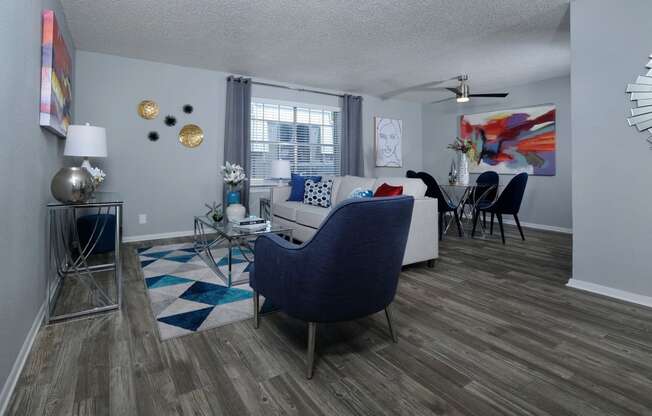 Living room and dining area in Stadium 700 apartments in Arlington  tx with modern furniture, luxury plank flooring, and large window.