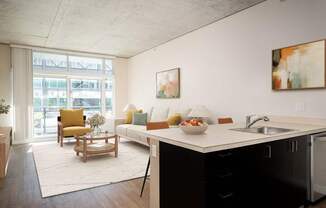 a living room with a kitchen and a large window