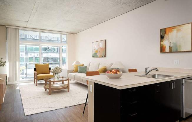 a living room with a kitchen and a large window