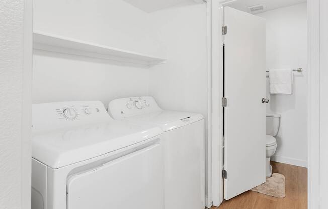 A white washing machine and dryer in a small laundry room.