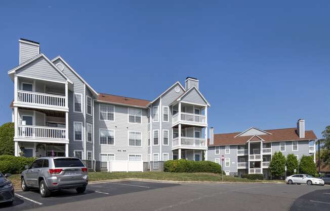 a large apartment complex with cars parked in front of it