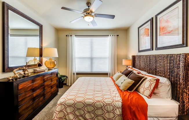 a bedroom with a large bed and a ceiling fan