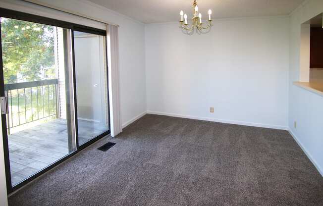 A room with a grey carpet and a chandelier.