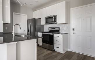 a kitchen with white cabinets and stainless steel appliances