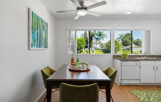 a dining room with a table and chairs and a ceiling fan