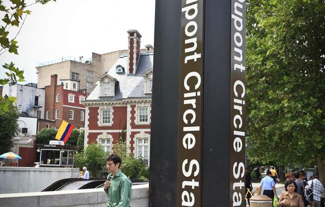 a man talking on a cell phone next to a sign