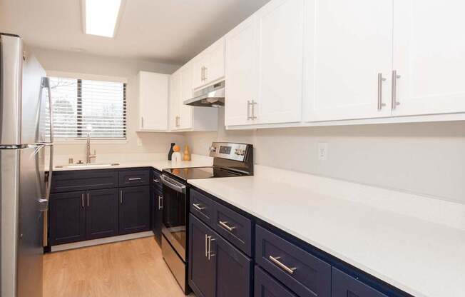 A kitchen with dark blue cabinets and white countertops.