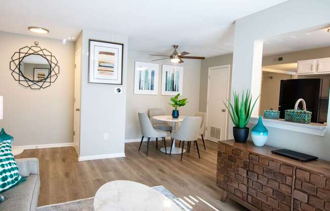 A living room with a grey couch, a white coffee table, a wooden cabinet, and a mirror on the wall.