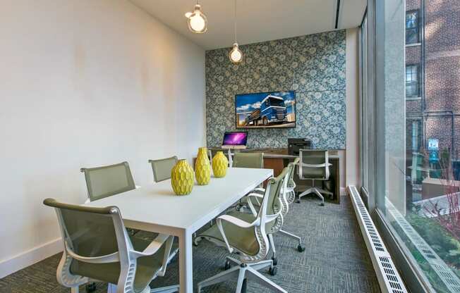 a conference room with a table and chairs and a large window