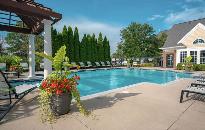 A pool surrounded by trees and a building.