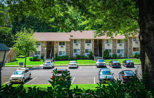 a parking lot with cars in front of an apartment building