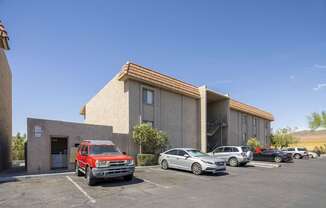 A parking lot with cars and a building in the background.