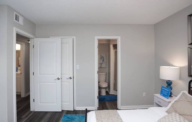 A bedroom with a bed, nightstand, and a lamp.