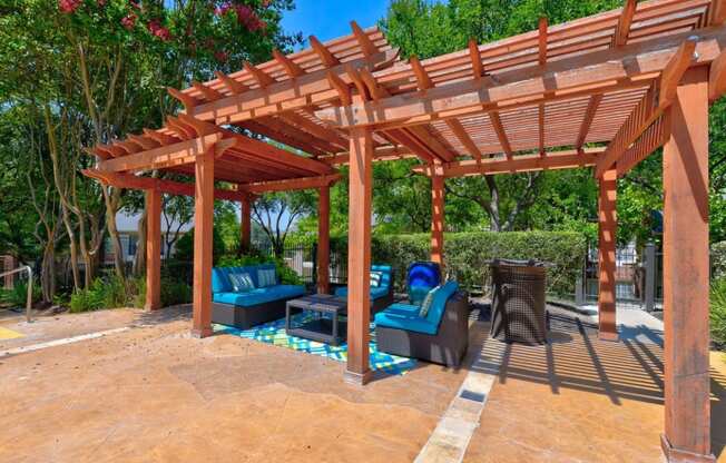 a wooden pergola with seating area