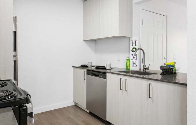 A kitchen with white cabinets and a black stove top.