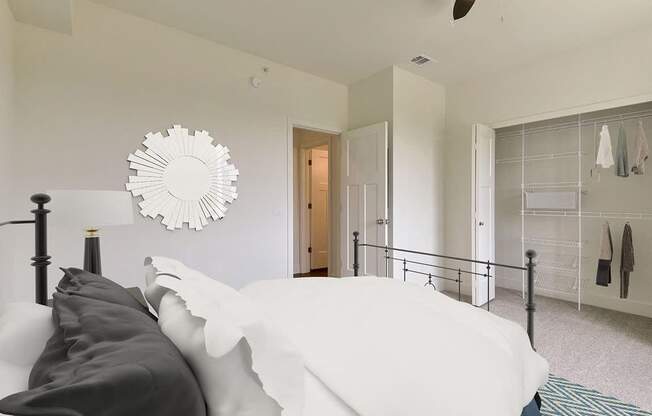 A bedroom with a bed and a walk in closet at Dodson Pointe Apartment Homes, Rogers