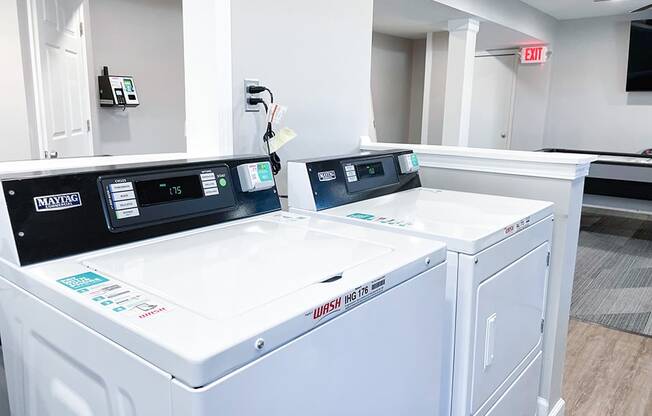 a laundry room with two washers and two dryers