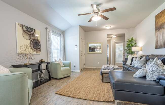 a living room with a ceiling fan and hardwood flooring