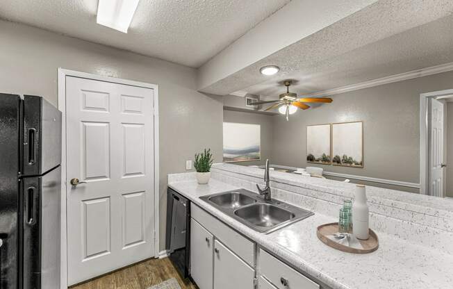 a kitchen with a sink and a ceiling fan