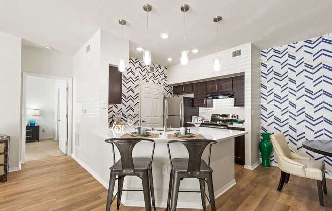 a view of a kitchen with a bar and stools