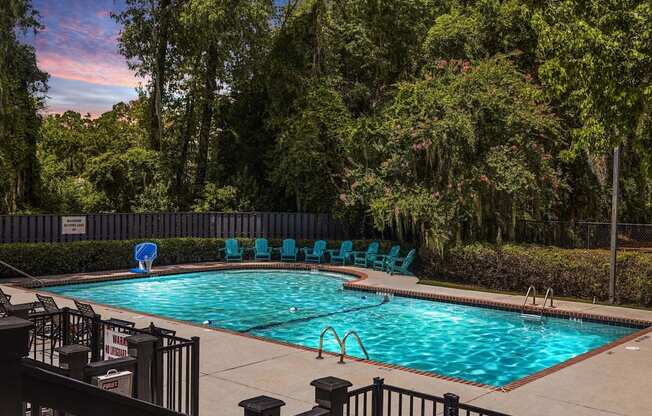 Greentree Apartments in Savannah, GA photo of a resort style swimming pool with blue chairs around it