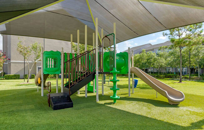 a playground with a play set under a canopy at Summerwind, Pearland, TX