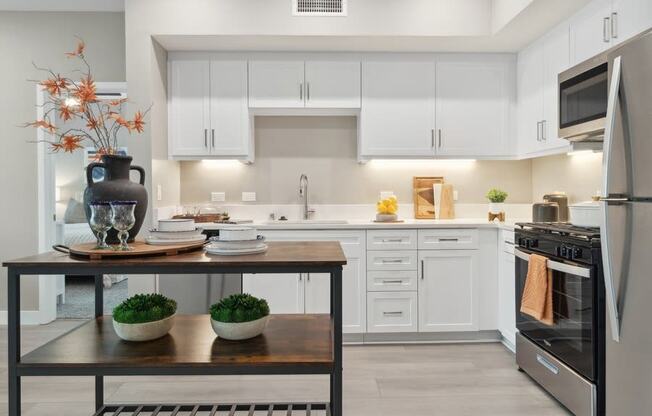 a kitchen with white cabinets and an island at Arrive Temecula