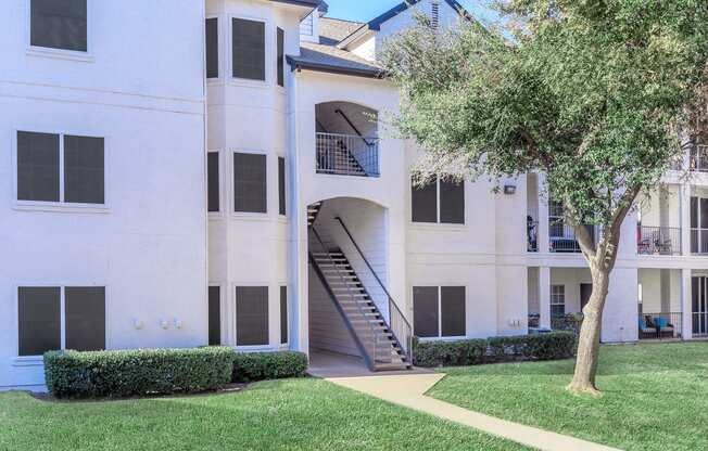 a large white building with a tree in front of it