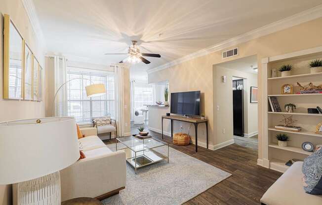 A living room with a white couch and a television.