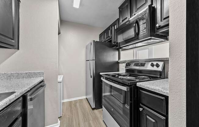 a kitchen with black and white appliances and a stainless steel refrigerator