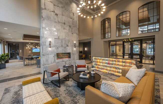 A modern living room with a stone fireplace and a large sectional sofa.