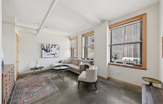 A living room with a rug, a couch, a chair, and a table.