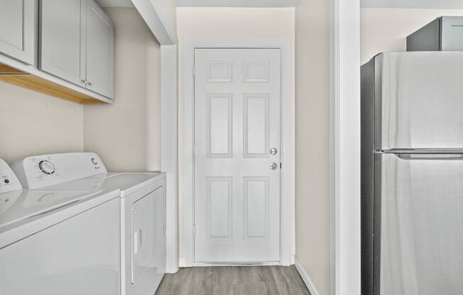 a white laundry room with a white refrigerator and a white door at Diamond Ridge Townhomes, Oklahoma City, OK 73114