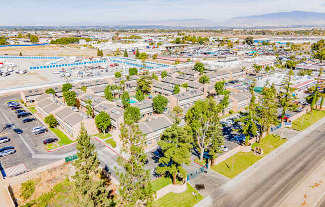 an aerial view of a parking lot with cars and trees