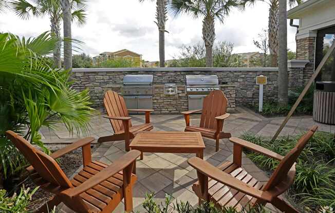 Four wooden chairs and a table are arranged on a patio.