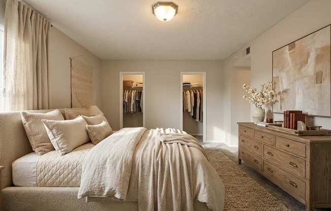 A bedroom with a large bed and a dresser.