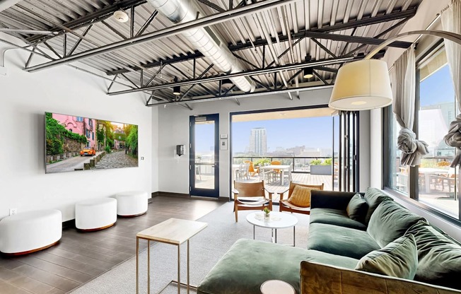 A living room with a green couch and a painting on the wall.