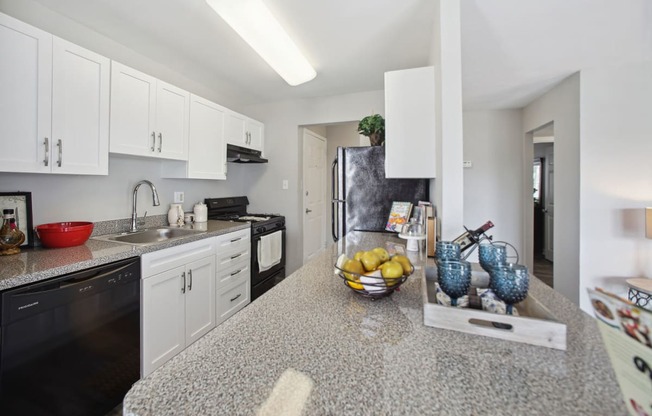 a kitchen with white cabinets and black appliances