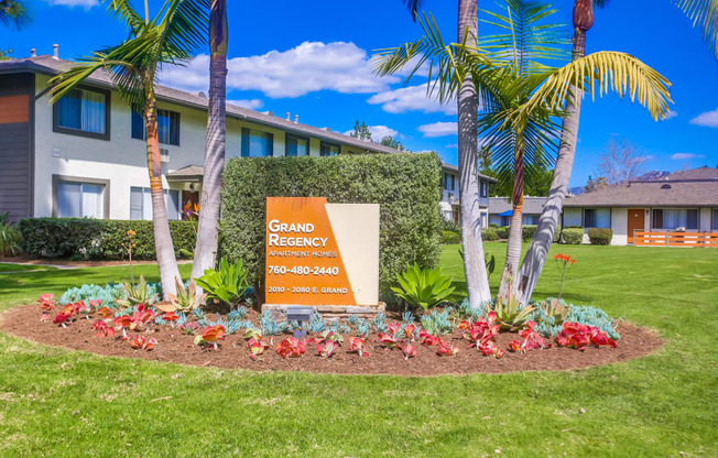 our sign in front of our home in the grass and palm trees